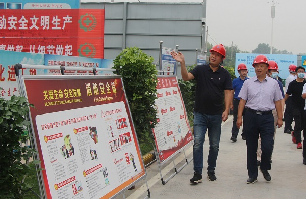 分公司經(jīng)理董書立向新鄉(xiāng)市住建局副局長王曉河介紹項目安全教育設施.jpg